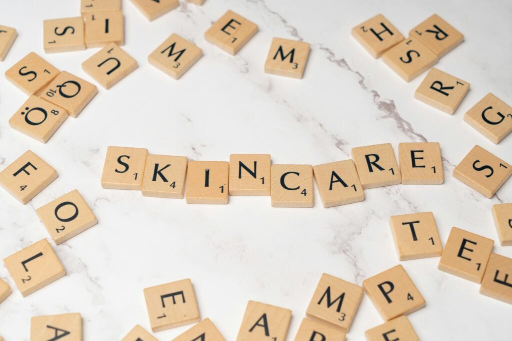 Wooden letter tiles spelling 'skincare' on a marble surface, symbolizing beauty.